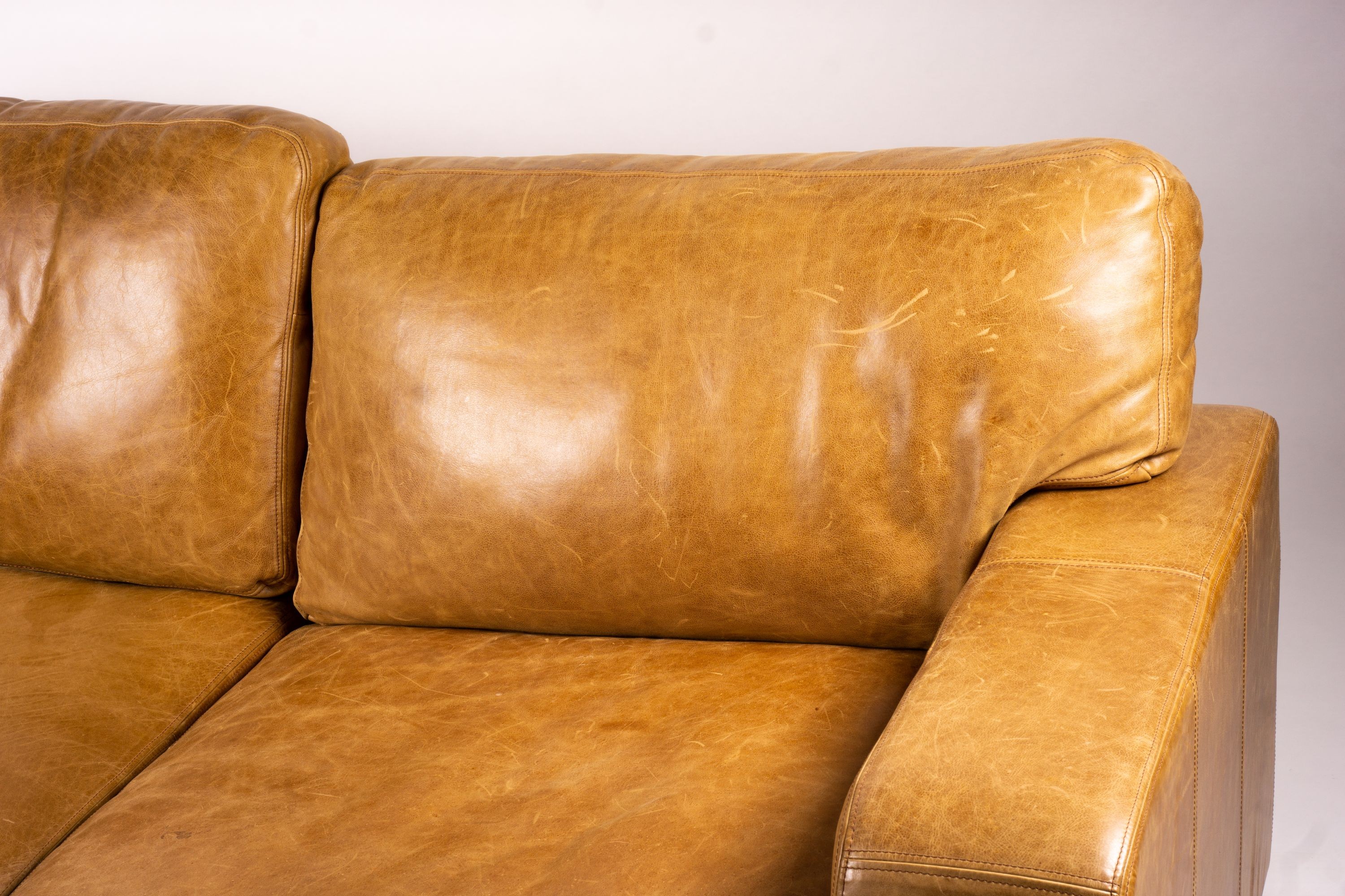 A pair of contemporary tan leather settees, length 200cm, depth 100cm, height 94cm